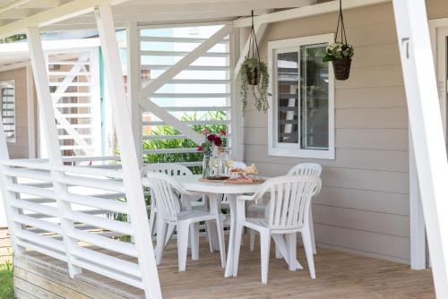 a white table and chairs on the porch of a house at Campeggio Paradiso in Sottomarina