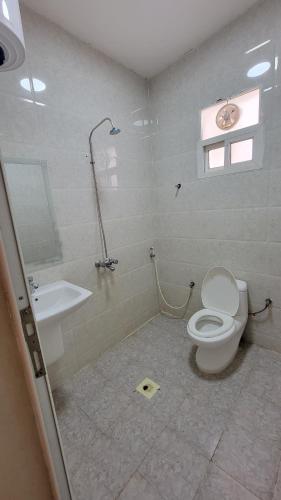 a bathroom with a toilet and a sink at Room Quriyat in Ramlah