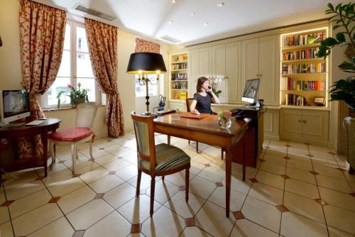 a hotel room with a desk and chairs at Le Relais Montmartre in Paris