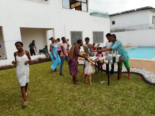 a group of people standing around a table in the grass at Residence Helios in Abidjan