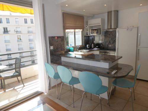 - une cuisine avec un comptoir avec des chaises et un comptoir dans l'établissement Palais Rouaze, à Cannes