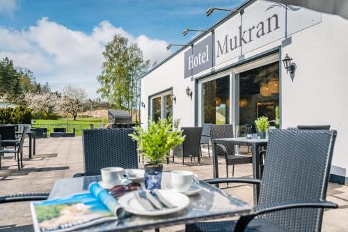 ein Tisch und Stühle vor einem Restaurant in der Unterkunft Hotel Mukran in Sassnitz