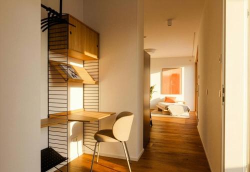 a small apartment with a staircase and a chair at TrulySpace - Modernes Apartment am Rathausplatz, Terrasse, Fahrstuhl in Augsburg