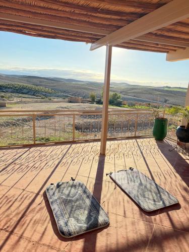 a deck with a view of the rolling hills at Les Jardins de la Santé in Tamazouzte