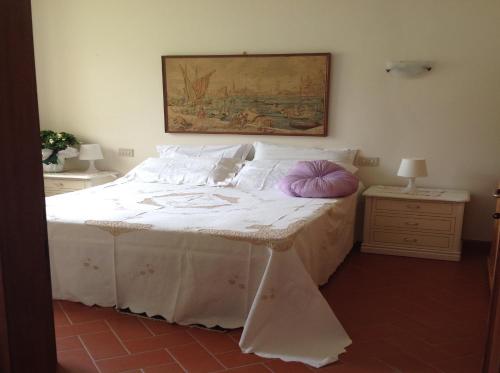 a bedroom with a bed with a purple pillow on it at Agriturismo La Casa Bianca in Poppi