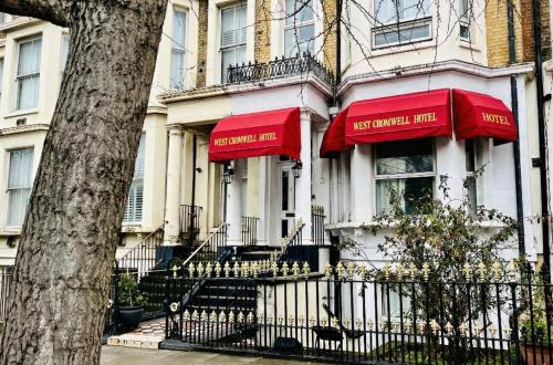 a house with red umbrellas on the front of it at West Cromwell Hotel in London