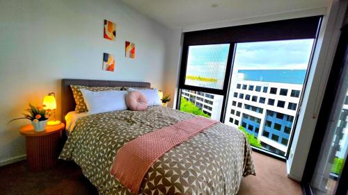 a bedroom with a bed and a large window at Bliss in City in Canberra