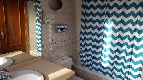 a bathroom with a sink and a shower curtain at Bungalow Mencey in El Médano