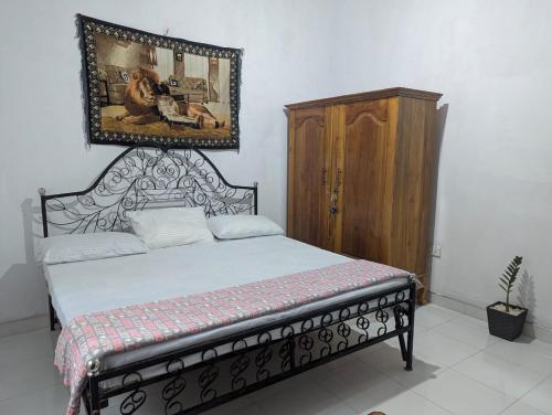 a bedroom with a bed and a painting on the wall at Wellassa Hillside Villa in Kendagolla