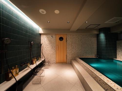 a swimming pool in a building with a pool at R Hotel RE Osaka Nagai Park in Osaka
