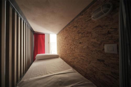 a bedroom with two beds and a brick wall at Dopa Hostel in Bologna