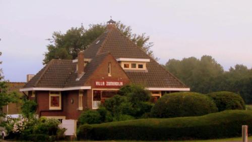 a large house with a roof with a tower at Villa Zomerdijk in Velsen-Zuid