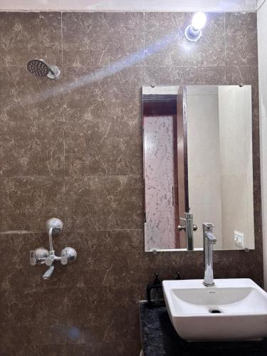 a bathroom with a sink and a mirror at Good vibes only gaur city center studio apartment in Ghaziabad