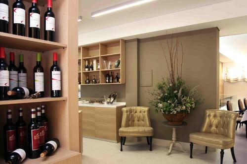 a wine cellar with bottles of wine and two chairs at Hotel Douro Inn in Tabuaço