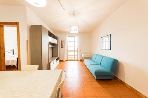 a living room with a blue couch in a room at Lily Flat - San Foca in San Foca