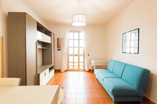 a living room with a blue couch in a room at Lily Flat - San Foca in San Foca