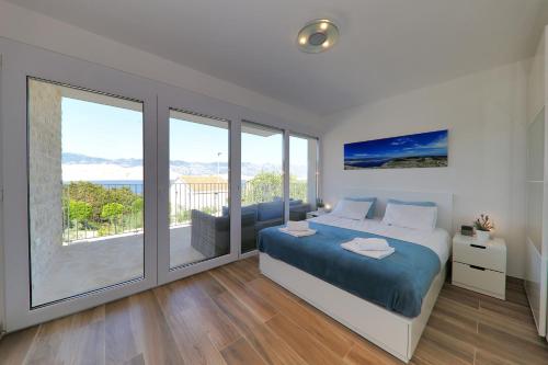 a bedroom with a large bed and a balcony at VILLA PAG - SVETA MARIJA in Pag