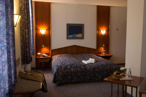 a hotel room with a bed and two tables at Klosterkrug Marienmünster in Marienmünster