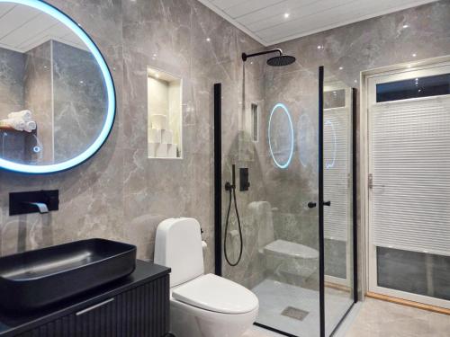 a bathroom with a shower and a toilet and a sink at Nybyggt hus med 3 sovrum, jacuzzi och närhet till strand in Bergkvara