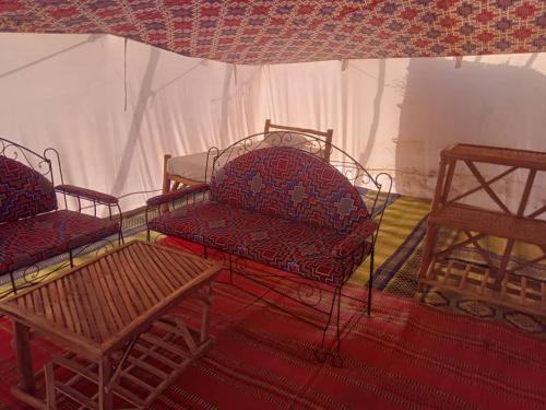 a room with two chairs and a couch and a table at Etoile du Désert de Lompoul in Kébémèr