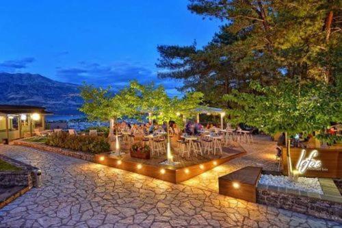 a group of tables and chairs in a park at night at Frontzu Politia in Ioannina