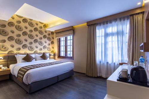 a hotel room with a bed and a large window at Boudha Boutique Hotel in Kathmandu