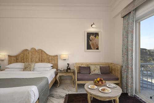 a bedroom with two beds and a table and a window at Fateh Safari Resort by Fateh Collection in Kumbhalgarh