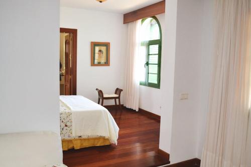 a bedroom with a bed and a window and a chair at Vista Timanfaya in Yaiza