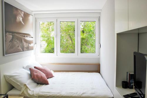 a bedroom with a bed and two windows at Gaius Apartment in Split