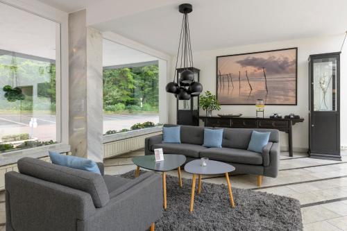 a living room with two couches and a table at Sunday Hotel des Nordens in Flensburg