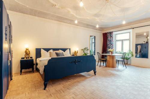 a bedroom with a blue bed and a table at Am Znaimertor in Retz