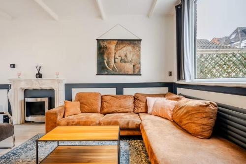 a living room with a brown couch and a table at Large Family House Alkmaar in Alkmaar