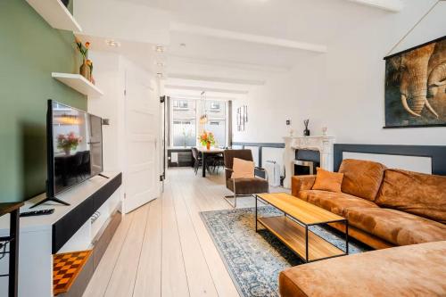 a living room with a couch and a tv at Large Family House Alkmaar in Alkmaar