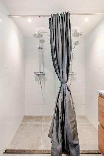 a shower with a curtain in a room at Large Family House Alkmaar in Alkmaar