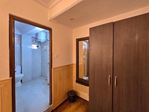 a bathroom with a shower and a toilet and a mirror at Newlands homestay near mall in Shimla