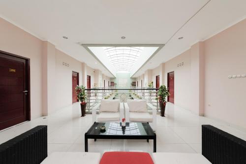 a hallway with chairs and a table in a building at Urbanview Hotel Niraz Banjarmasin by RedDoorz in Sungai Lutus