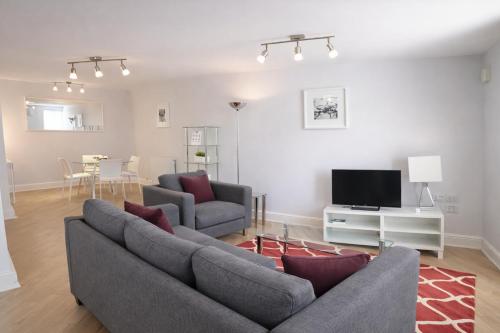a living room with a couch and a tv at Roomspace Serviced Apartments - The Courtyard in London