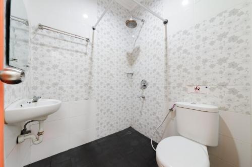 a bathroom with a toilet and a sink at Urbanview Hotel Niraz Banjarmasin by RedDoorz in Sungai Lutus
