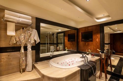 a bathroom with a large tub and a large mirror at Vivanta Hyderabad, Begumpet in Hyderabad