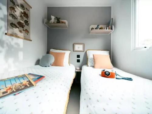 two beds in a small room with a toy on it at ZEcamping 3 étoiles vue exceptionnelle et soirées animées in Gex