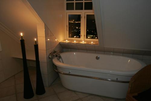 a bath tub in a bathroom with two candles at Vikinghaug in Odda