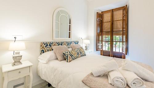 a white bedroom with a bed and a window at Apartamento Garcia Lorca Granada in Granada