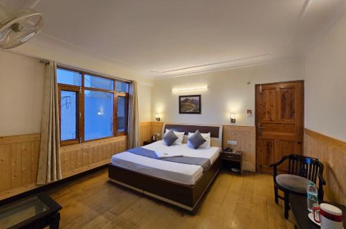 a bedroom with a bed and a large window at Newlands homestay near mall in Shimla