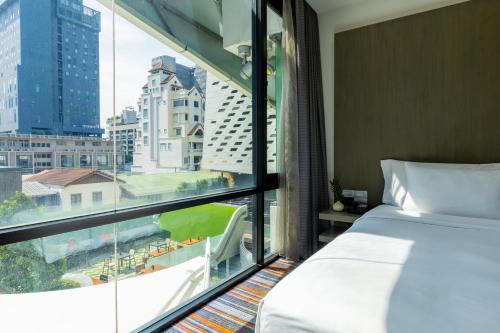 a hotel room with a bed and a large window at LiT BANGKOK Hotel in Bangkok