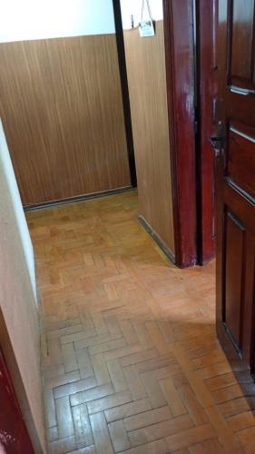 a hallway with a wooden floor and a wooden door at Pausada Regis in Lavras