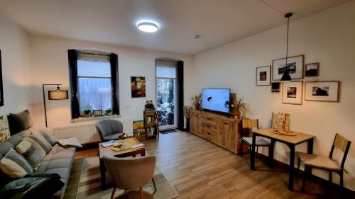 ein Wohnzimmer mit Sofa und Tisch in der Unterkunft Johnis FeWo, Nähe Stadtzentrum - Uni in sehr ruhiger Lage mit Terrasse und eigenem Parkplatz in Cottbus