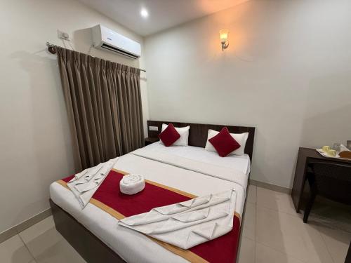 a bedroom with a bed with red pillows at Hotel Fortune 36 in Bangalore