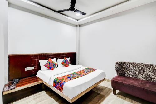 a bedroom with a bed and a couch at FabHotel P2 And Resort in Bhopal