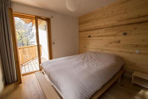 - une chambre avec un lit et un mur en bois dans l'établissement Les Sabots d'Hélène, à Valloire