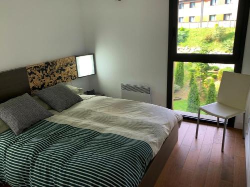 a bedroom with a large bed and a window at Apartament 5 persones Llar de Foc i Piscina in Saillagouse